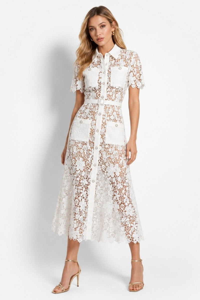Woman wearing an elegant white floral lace button down midi shirt dress with belt, standing in a sophisticated pose against a white background.