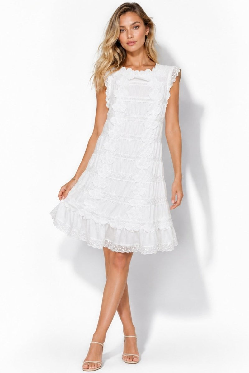 Woman wearing Kouvr white lace tiered sleeveless mini dress with floral applique