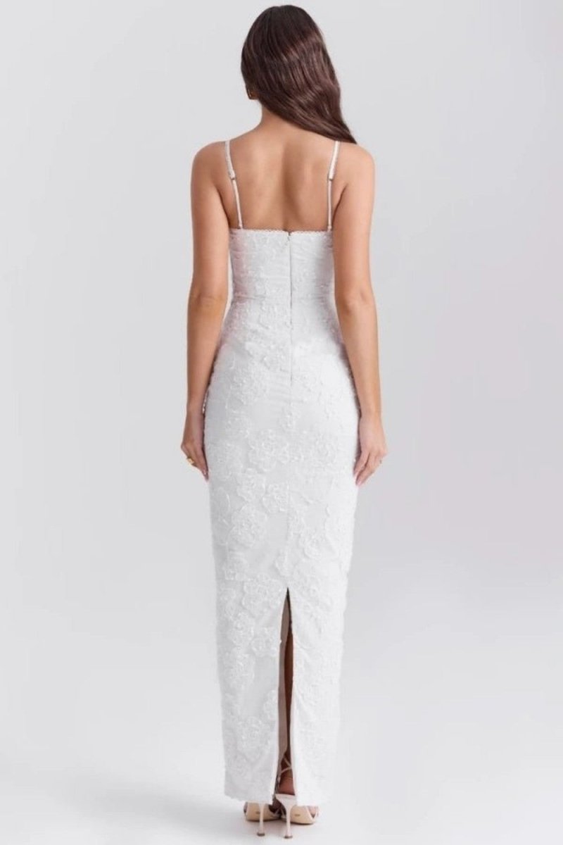 Woman wearing a white lace dress with thin straps on a light gray background
