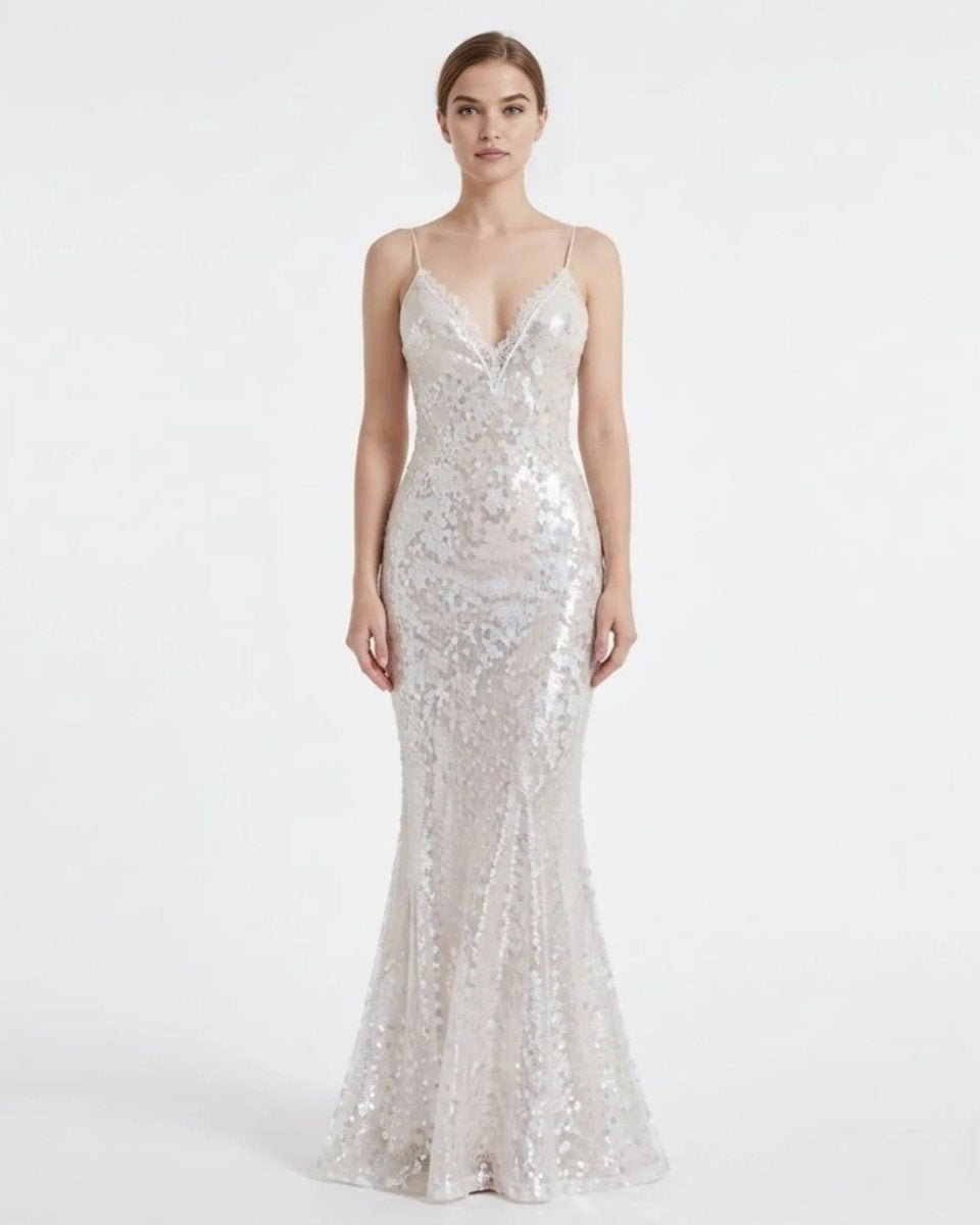 Front view of a female model wearing a luxurious white sequin V-neck mermaid evening gown by Kouvr, featuring a floor-length sweeping hem.