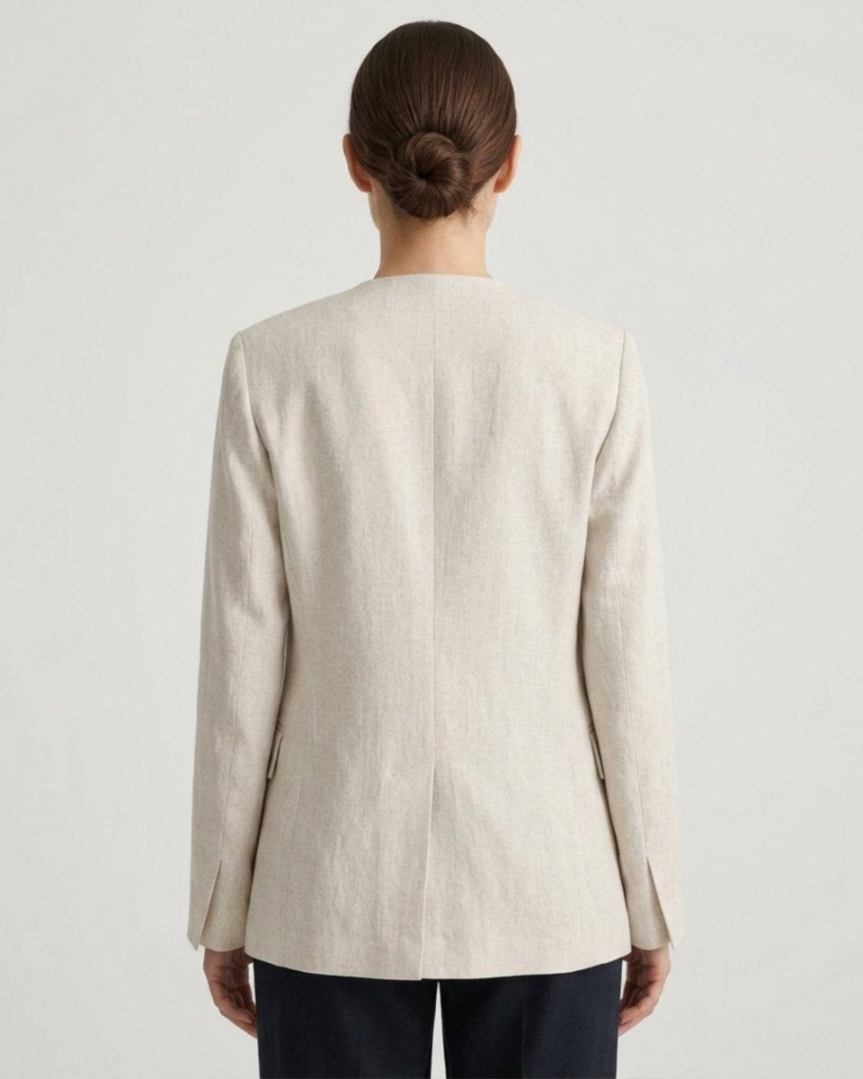 Back view of a tailored light beige single button women's blazer with a center back vent.