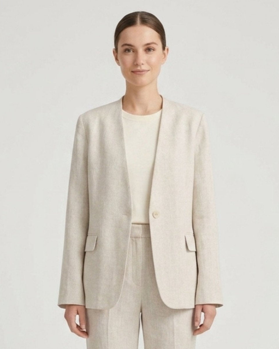 Woman wearing a light beige collarless linen blazer over a white top, front view studio shot.