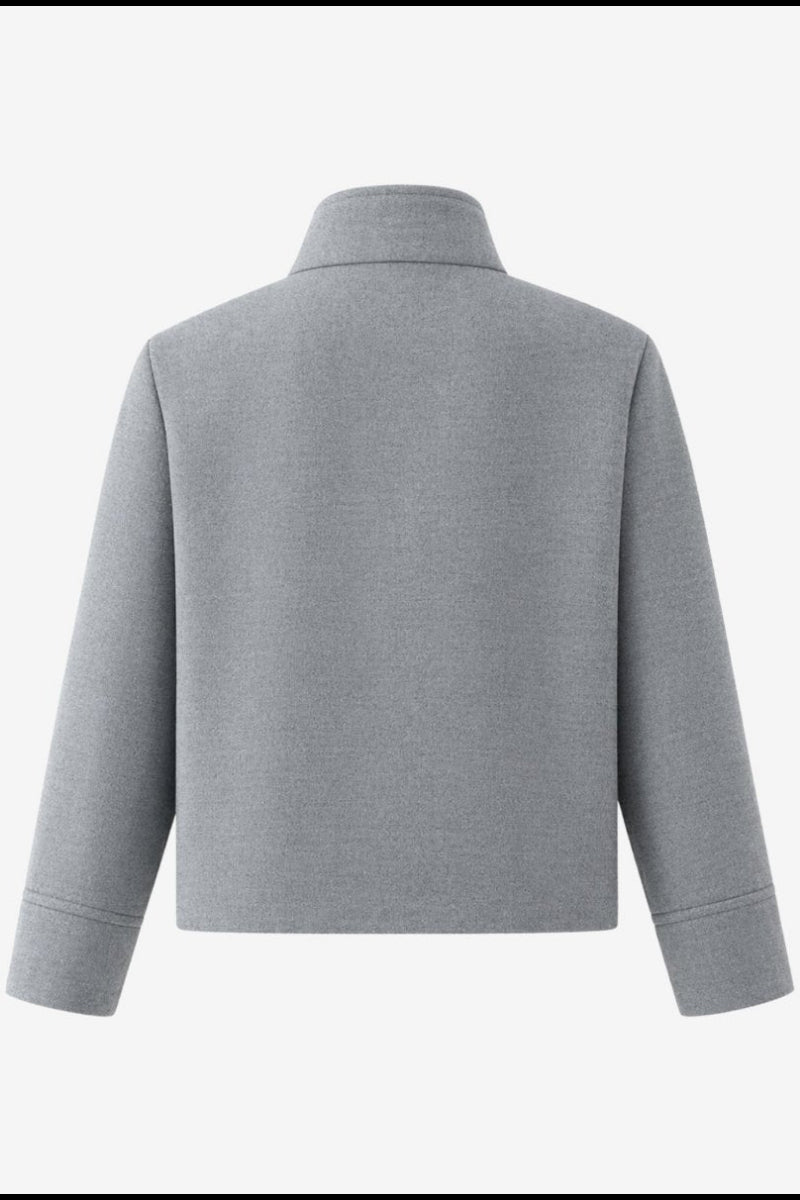 Flat lay back view of a minimalist grey short outerwear coat showing structured shoulder and hem details.