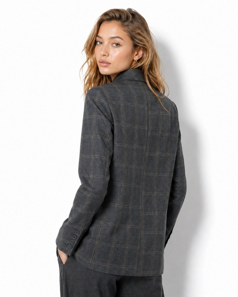 Back view of female model wearing the tailored grey check jacket showing back seam and cuff button details.