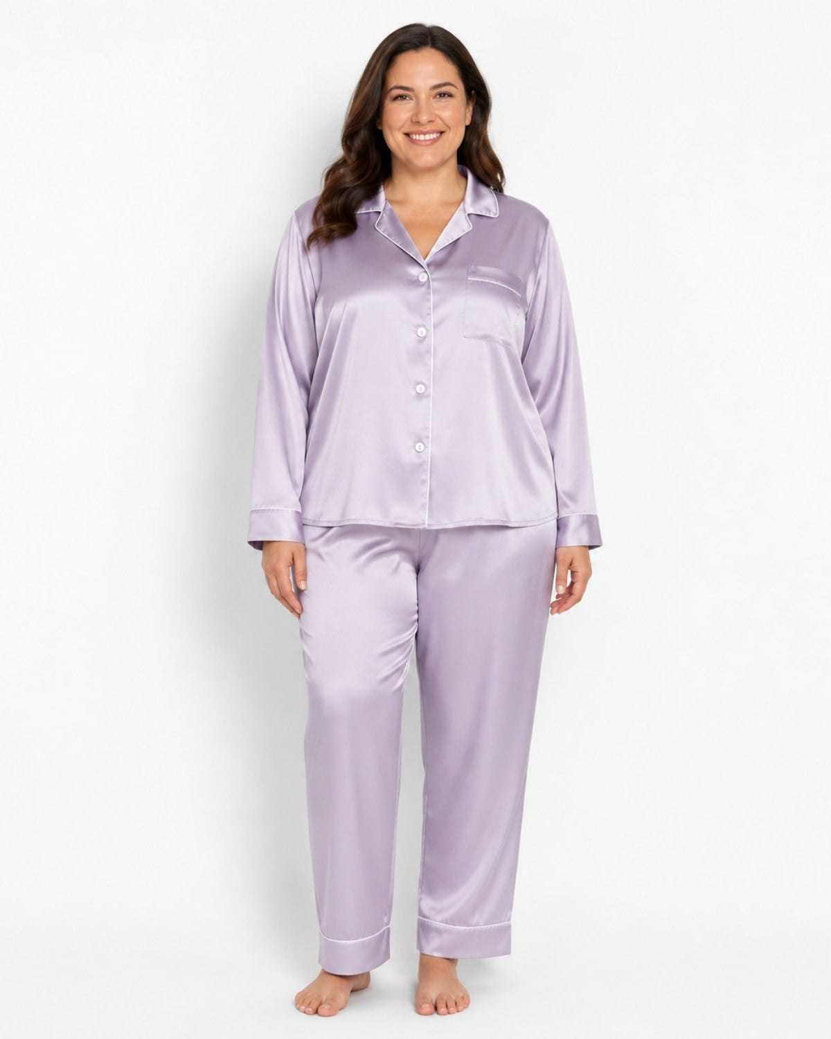 A woman modeling a two-piece lavender satin pajama set, featuring a long-sleeve button-up shirt and matching pants, against a plain white studio background.