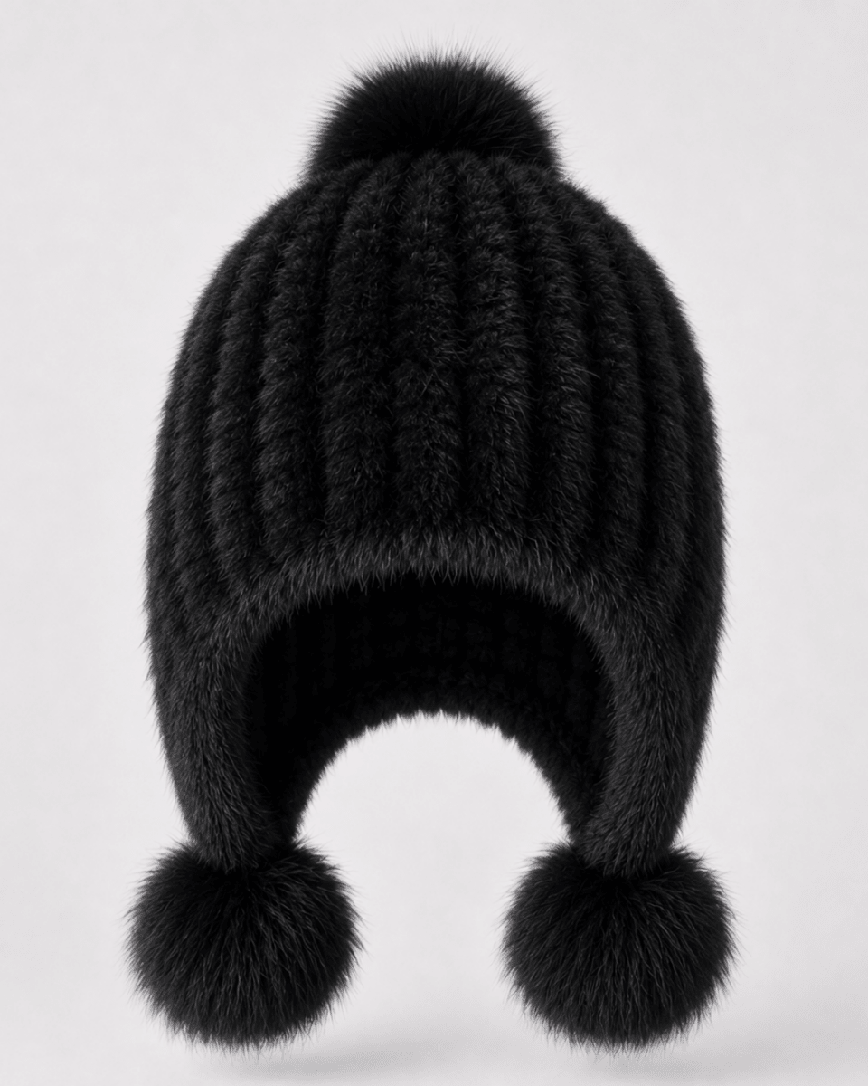 A black ribbed knit pom-pom beanie hat with ear flaps and fluffy pom-poms, shown against a plain light gray background.