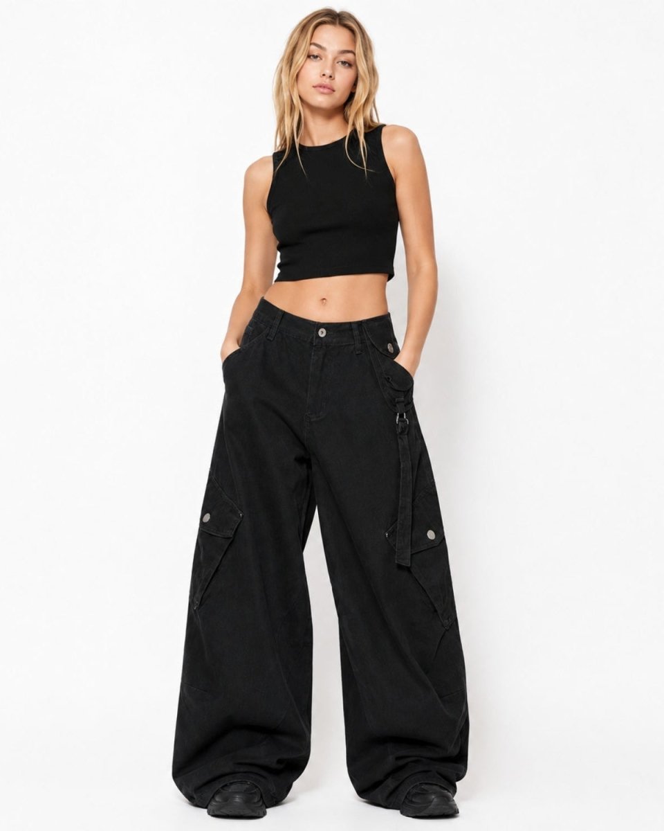 A woman modeling a black sleeveless crop top and black wide-leg cargo pants against a plain white studio background.