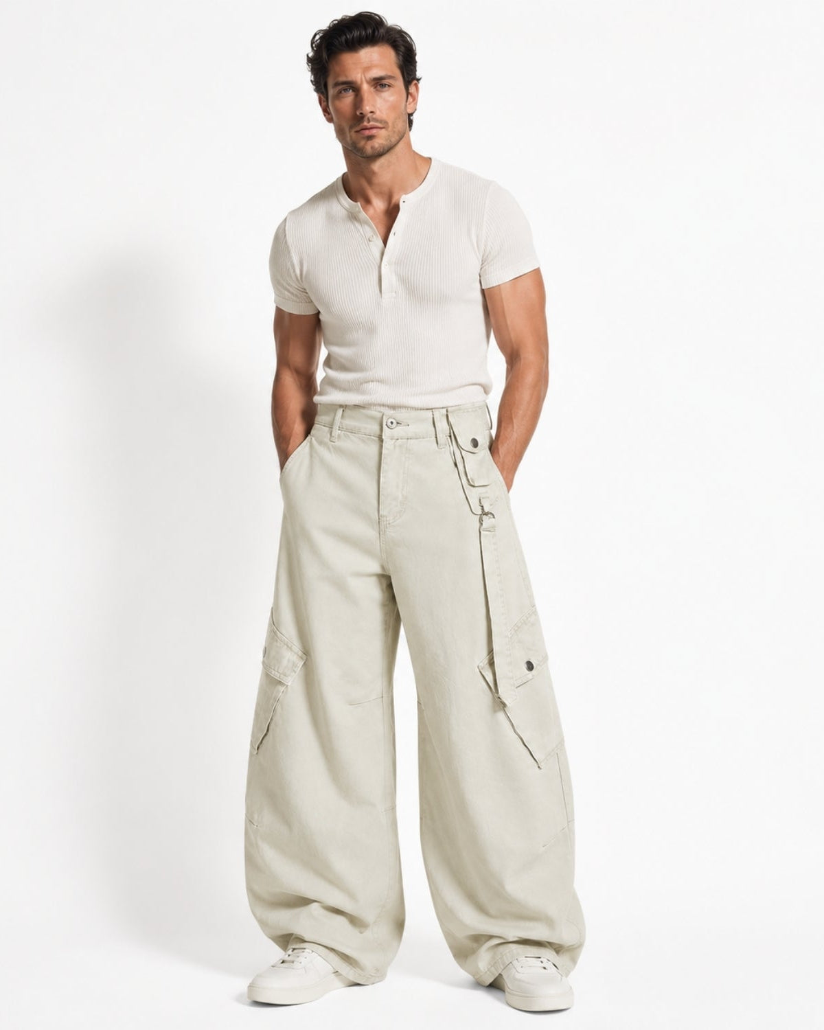 A male model wearing a cream short-sleeve henley shirt and matching cream wide-leg cargo pants, standing against a plain white studio background.