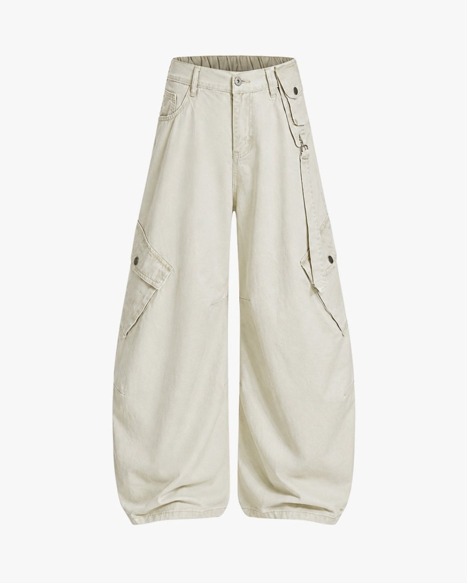 A pair of wide-leg cargo pants in a light cream or off-white color, featuring multiple utility pockets and button details, shown against a plain light gray background.