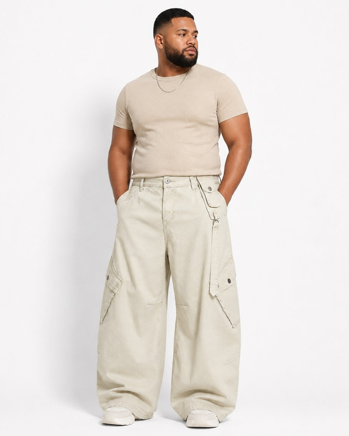 A man modeling a beige short-sleeve crewneck t-shirt and matching beige wide-leg cargo pants against a plain white studio background.