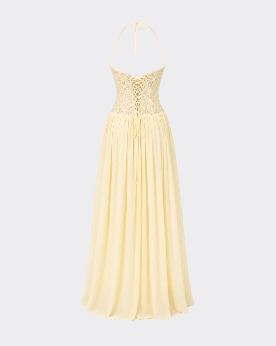 A pale yellow halter maxi dress with a lace-up corset bodice and flowing chiffon skirt, shown against a light gray background.