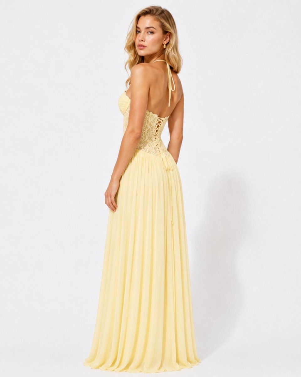 A woman modeling a pale yellow sleeveless maxi dress with a lace-up corset-style bodice and thin shoulder ties, shown from the back against a plain white studio background.