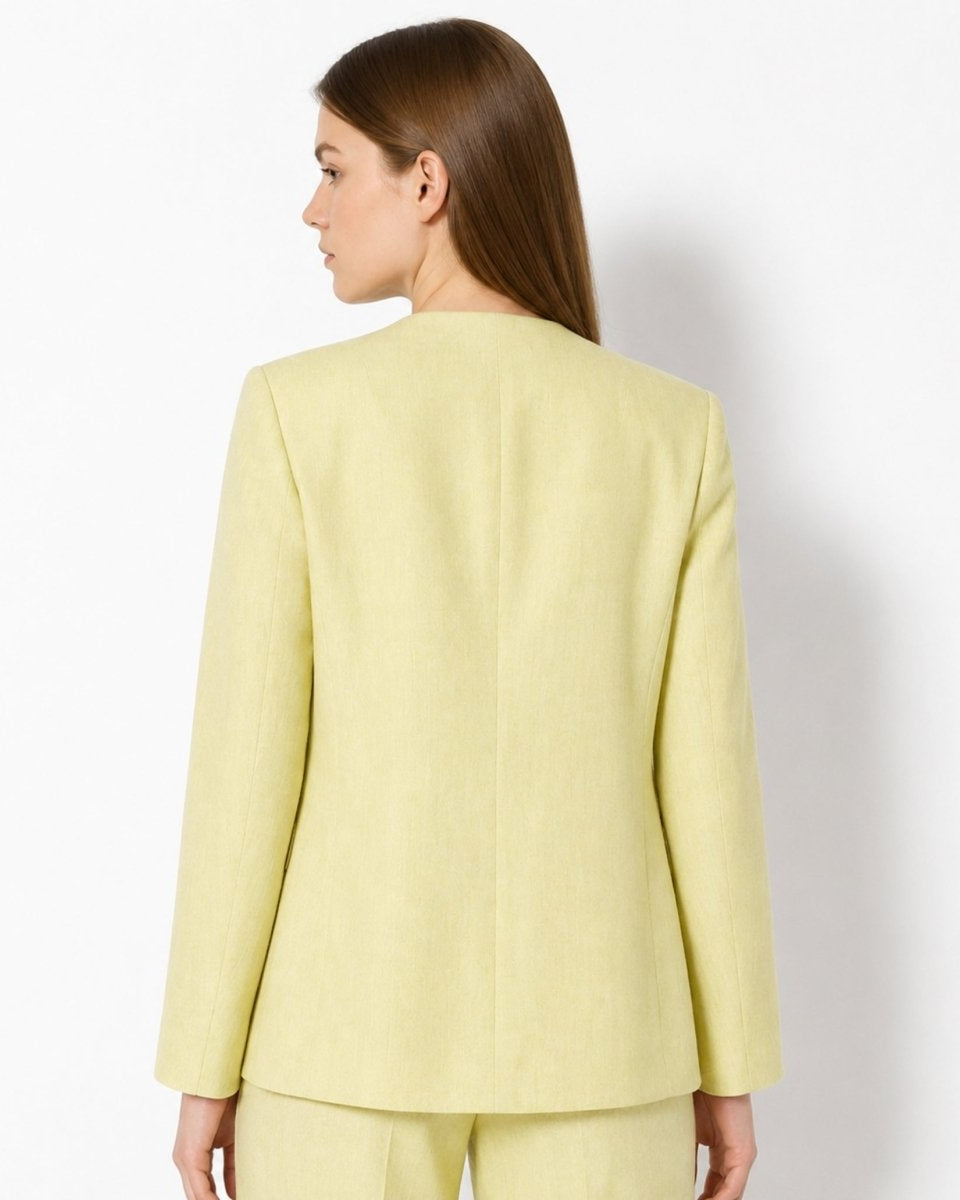 Back view of woman wearing Kouvr tailored yellow single button suit jacket.