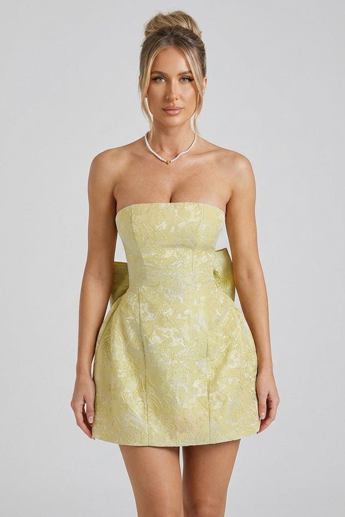 Close up half body portrait of model in a yellow coquette party dress with pearl necklace