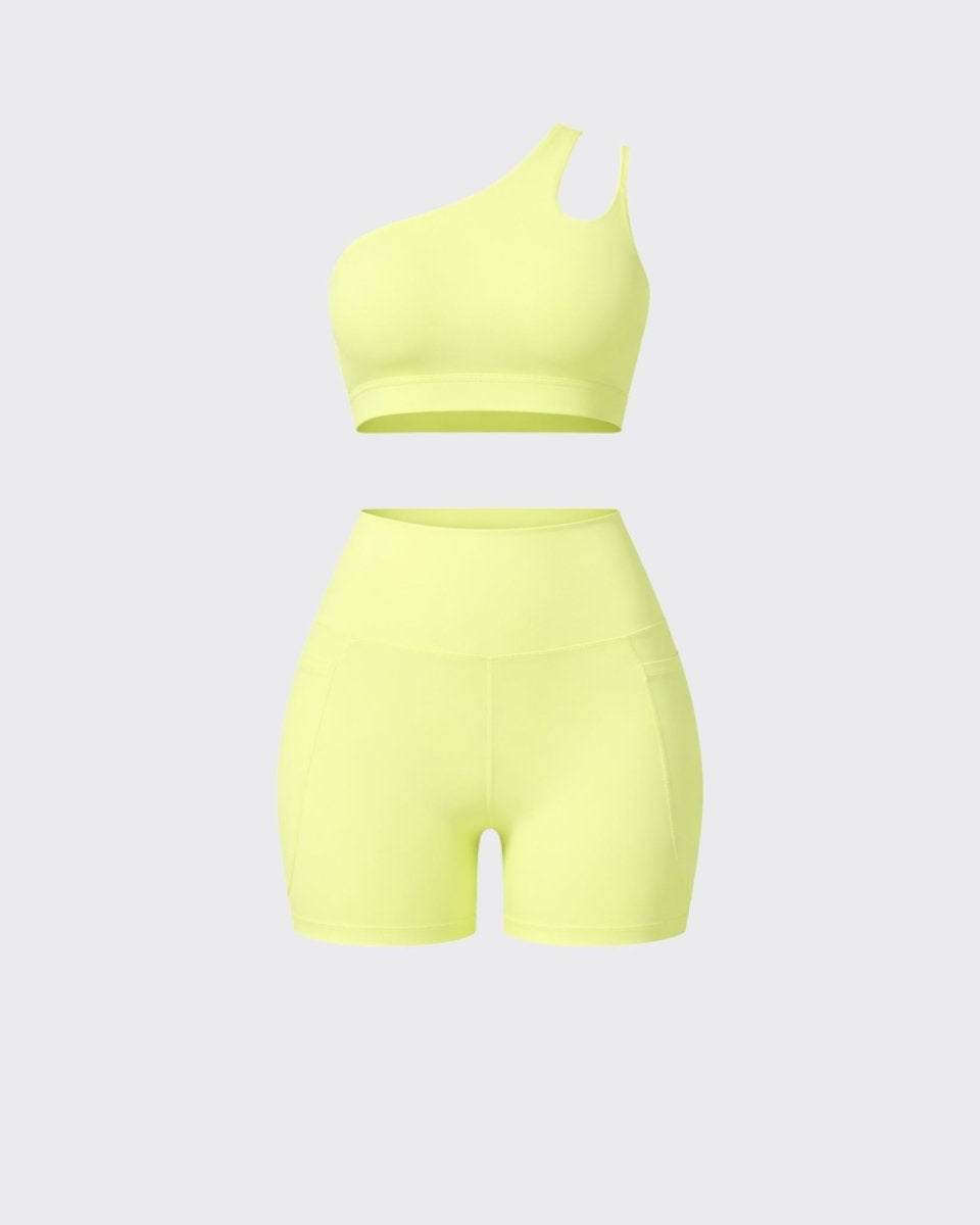 Front flatlay view of yellow two piece activewear suit with asymmetric sports bra and high waist pocket shorts