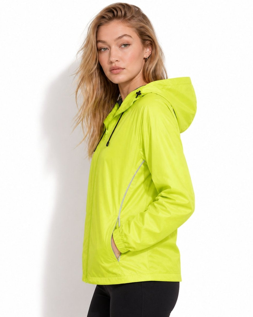 Side profile of female model wearing yellow lightweight hooded rain shell with reflective piping